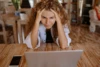 A woman frustrated in front of a laptop